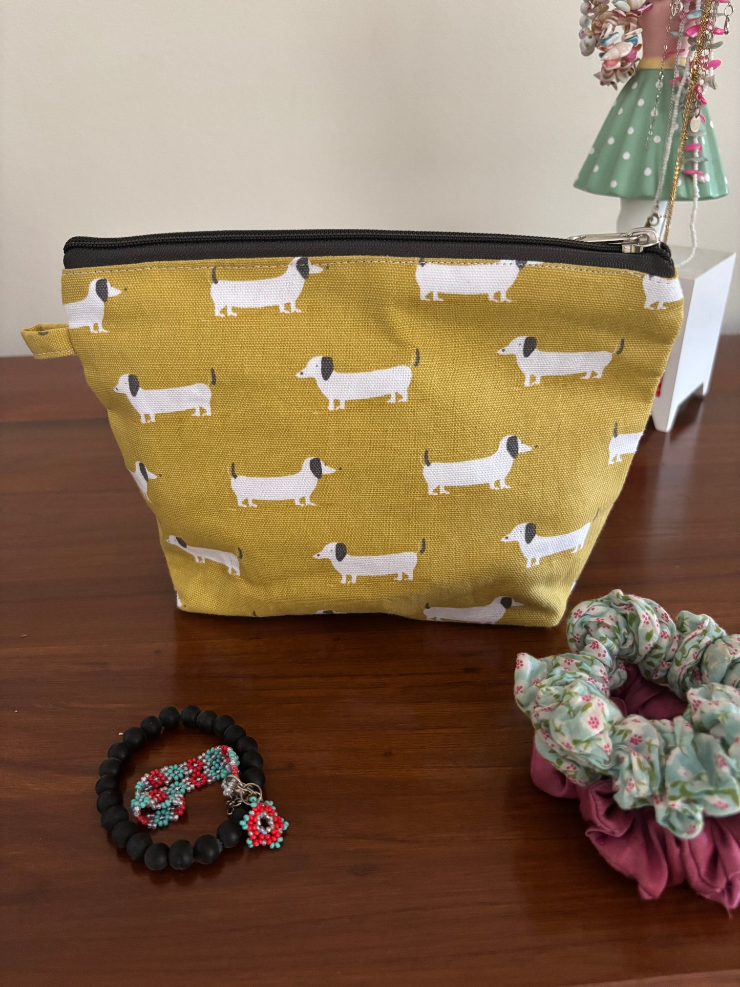 Yellow fabric pouch with dog pattern on a wooden surface