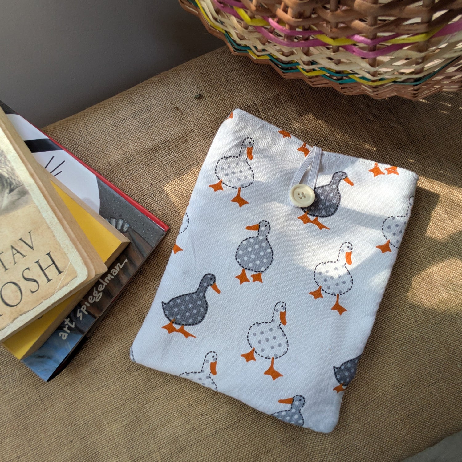 There is a book cover or book sleevsekept next to a small stack of books