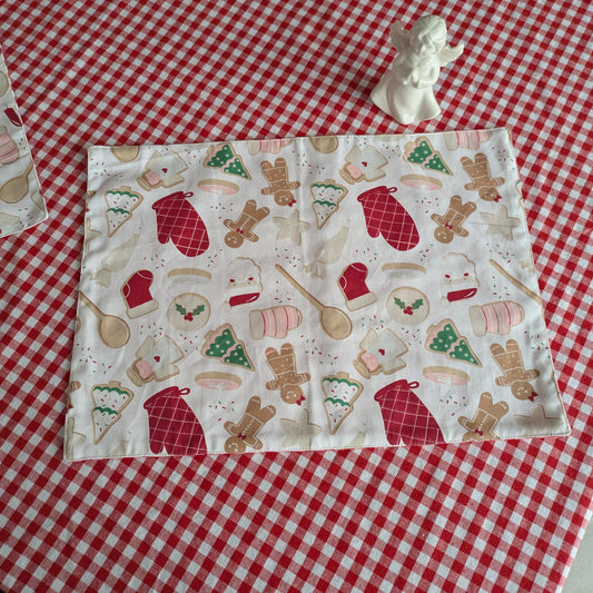 Fabric with Christmas-themed pattern table mat on a red and white checkered tablecloth