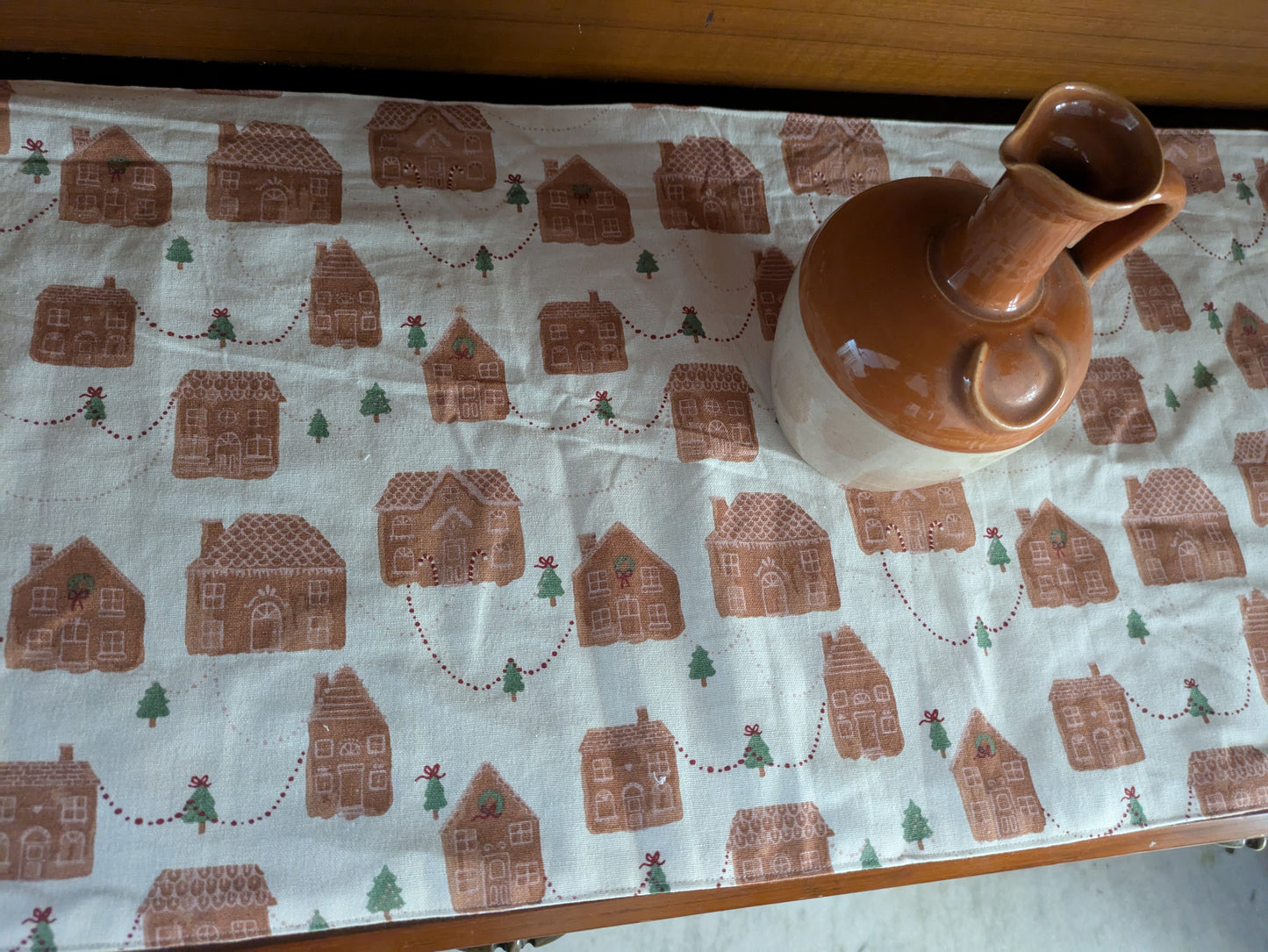 Tablecloth with gingerbread house pattern on a wooden table