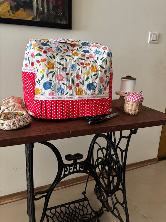 swingmachine table witha fabric sewing machine cover and other sewing notions placed on the table
