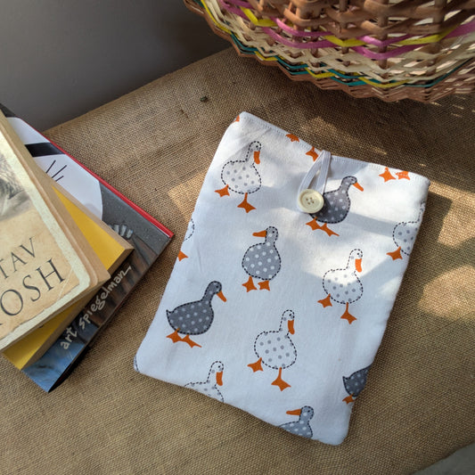 There is a book cover or book sleevsekept next to a small stack of books