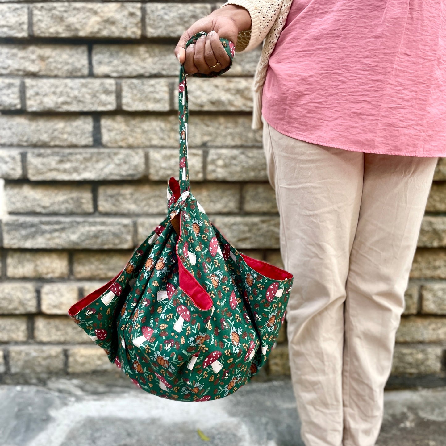 A woman carrying a casserole dish neatly wrapped in a casserole carrier.