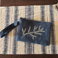 Blue pouch with floral embroidery on a striped fabric surface