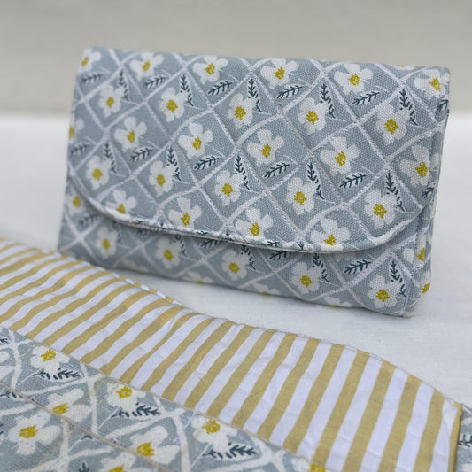Floral patterned clutch bag on a striped fabric background