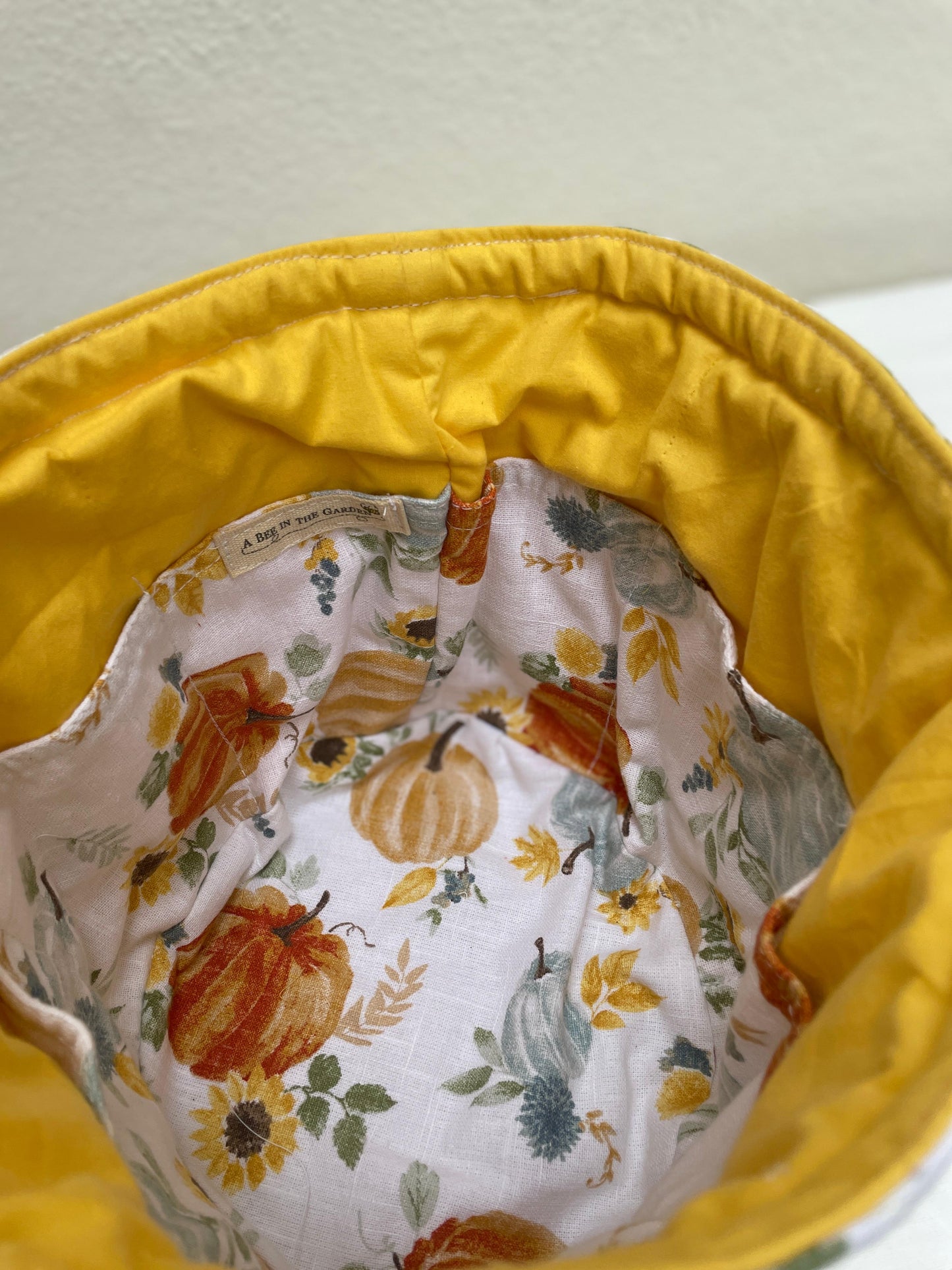 Yellow fabric with a floral and pumpkin patterned lining