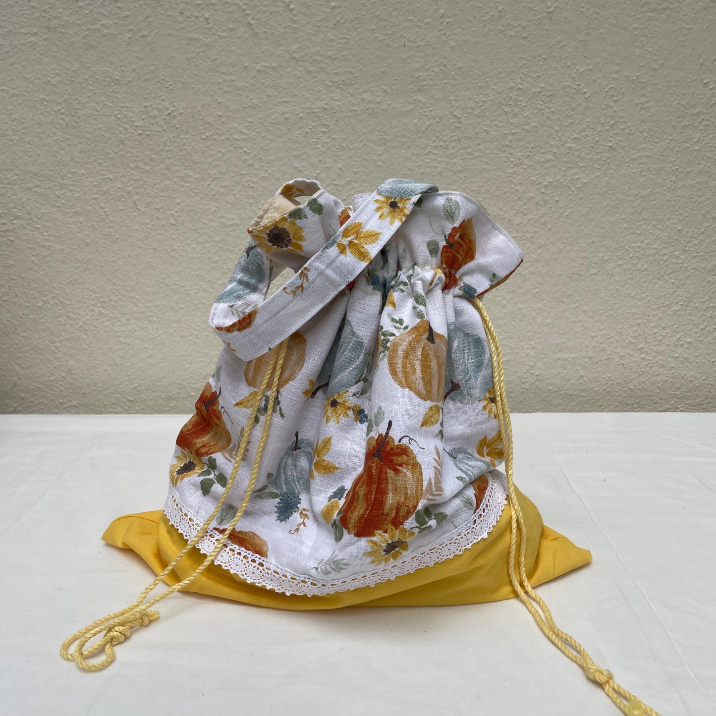Drawstring bag with autumn-themed design on a white surface