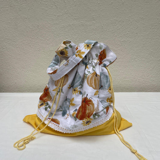 Drawstring bag with autumn-themed design on a white surface
