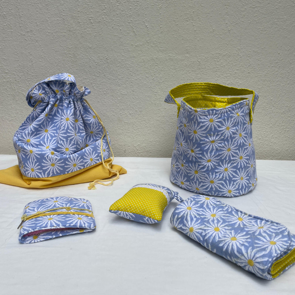 Set of fabric bags with blue floral pattern and yellow accents on a white surface.