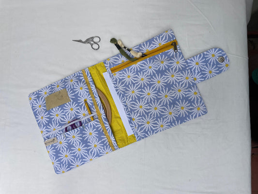 Fabric sewing folder with floral pattern on a white background, it has pockets for all sewing tools and ntions
