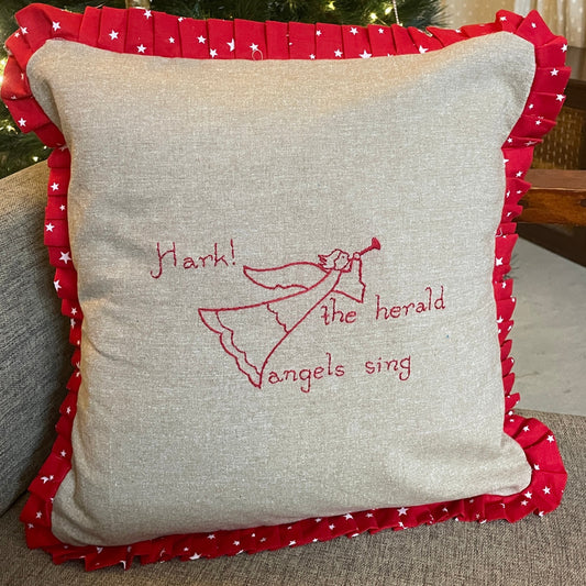 Hand embroidered beige cushion cover with red accents and text 'MARK! HERALD ANGELS' on a Christmas tree background.