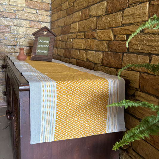 Table with a patterned tablerunneragainst a stone wall