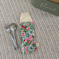 Floral-patterned bread box with a knife and fork on a textured surface