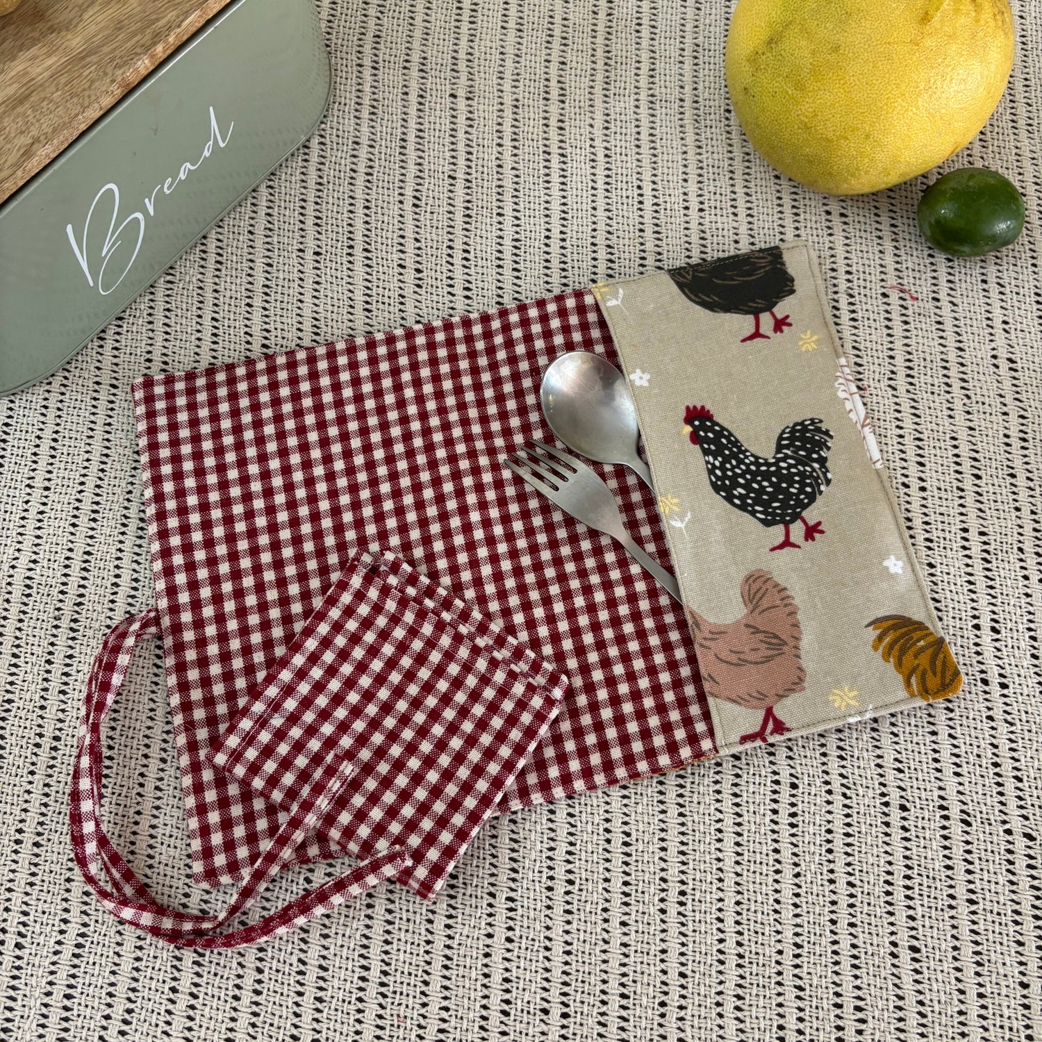 Fabric with chicken pattern and red checkered material on a textured surface