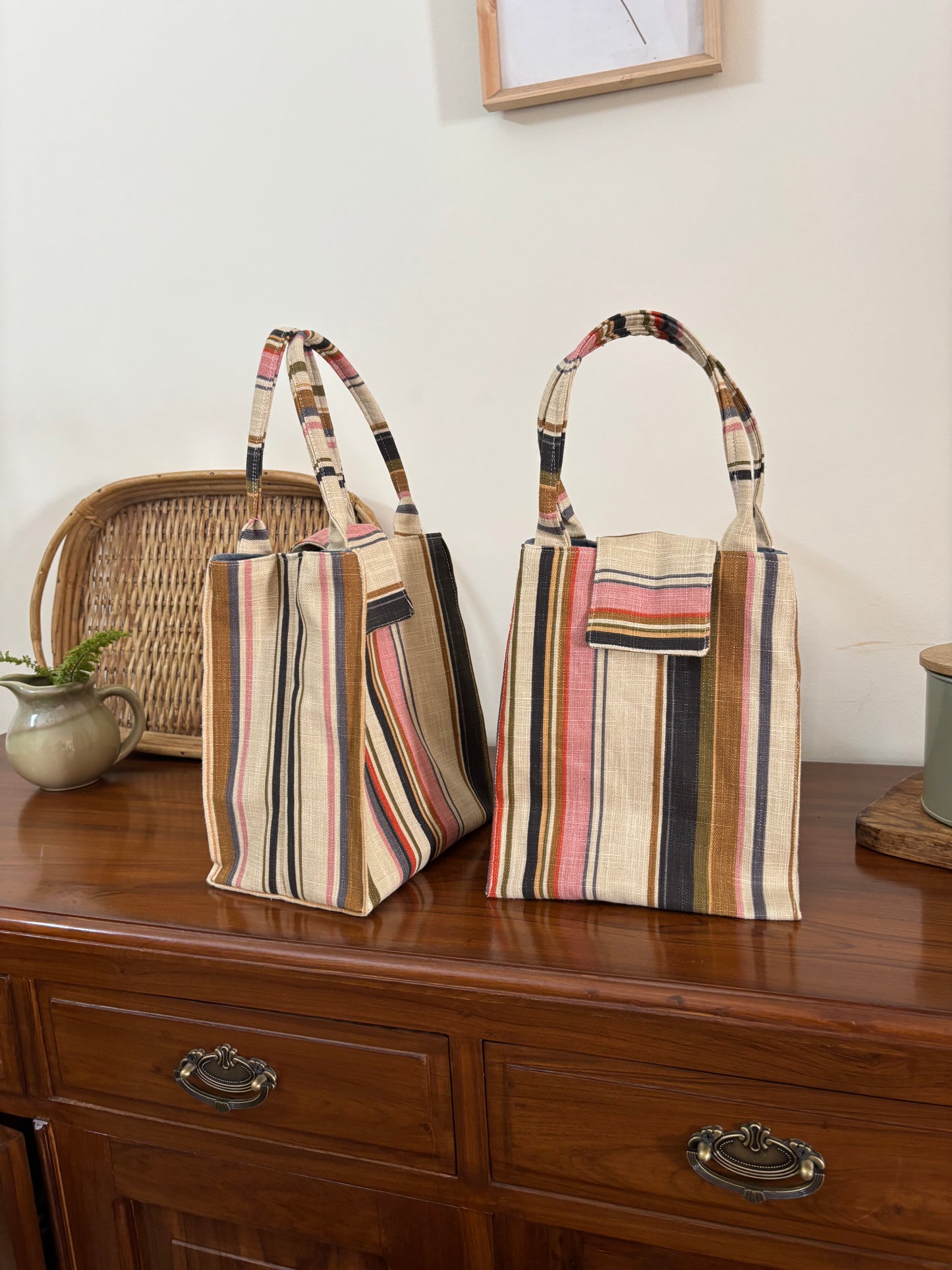 Striped handbags on a wooden surface with a neutral background