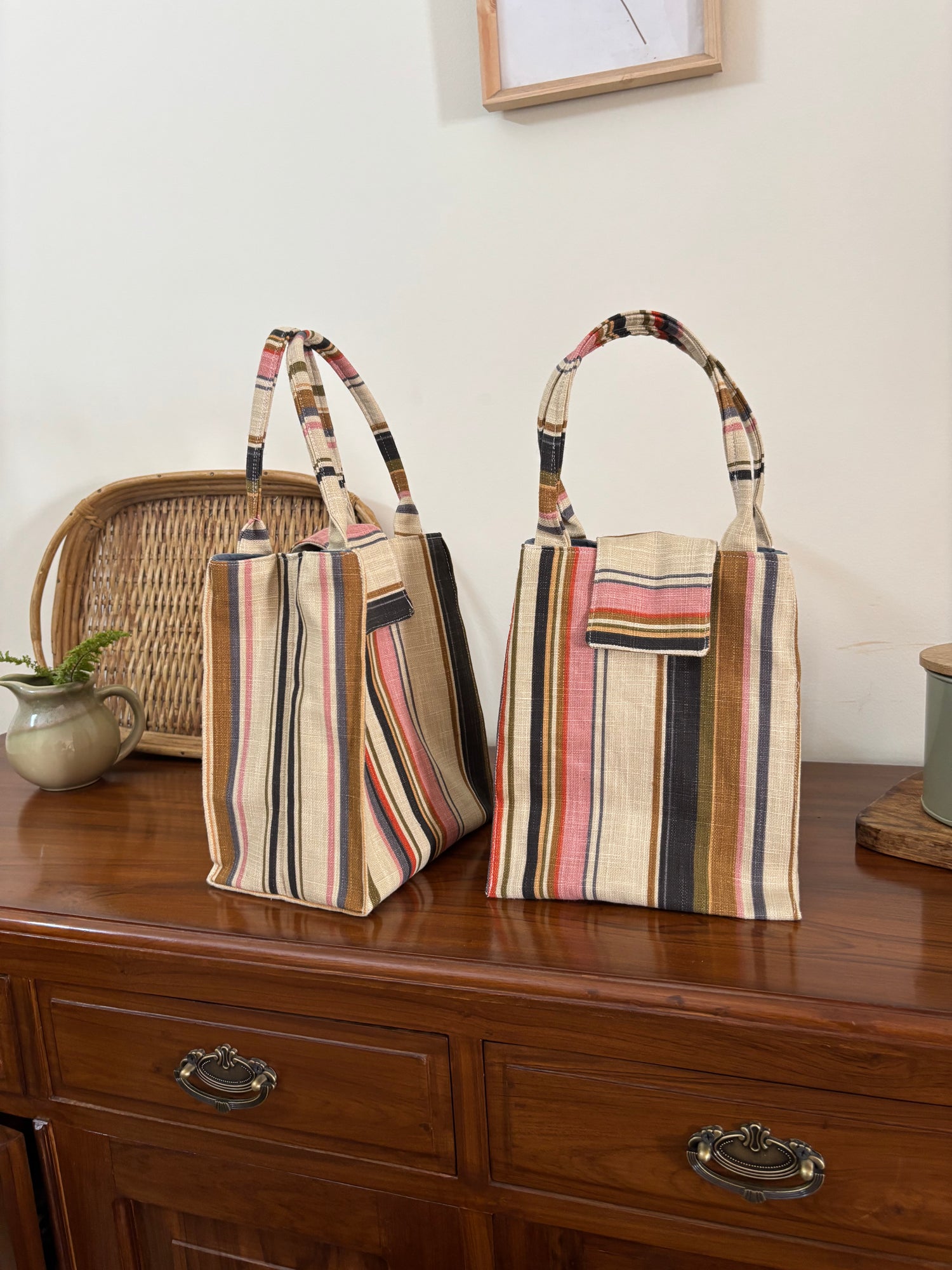Striped handbags on a wooden surface with a neutral background