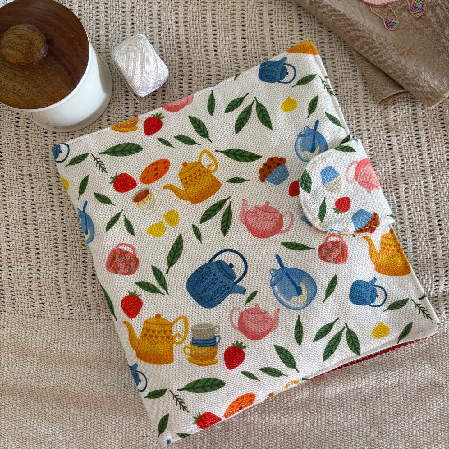 Baby bib with colorful teapot design on a textured surface
