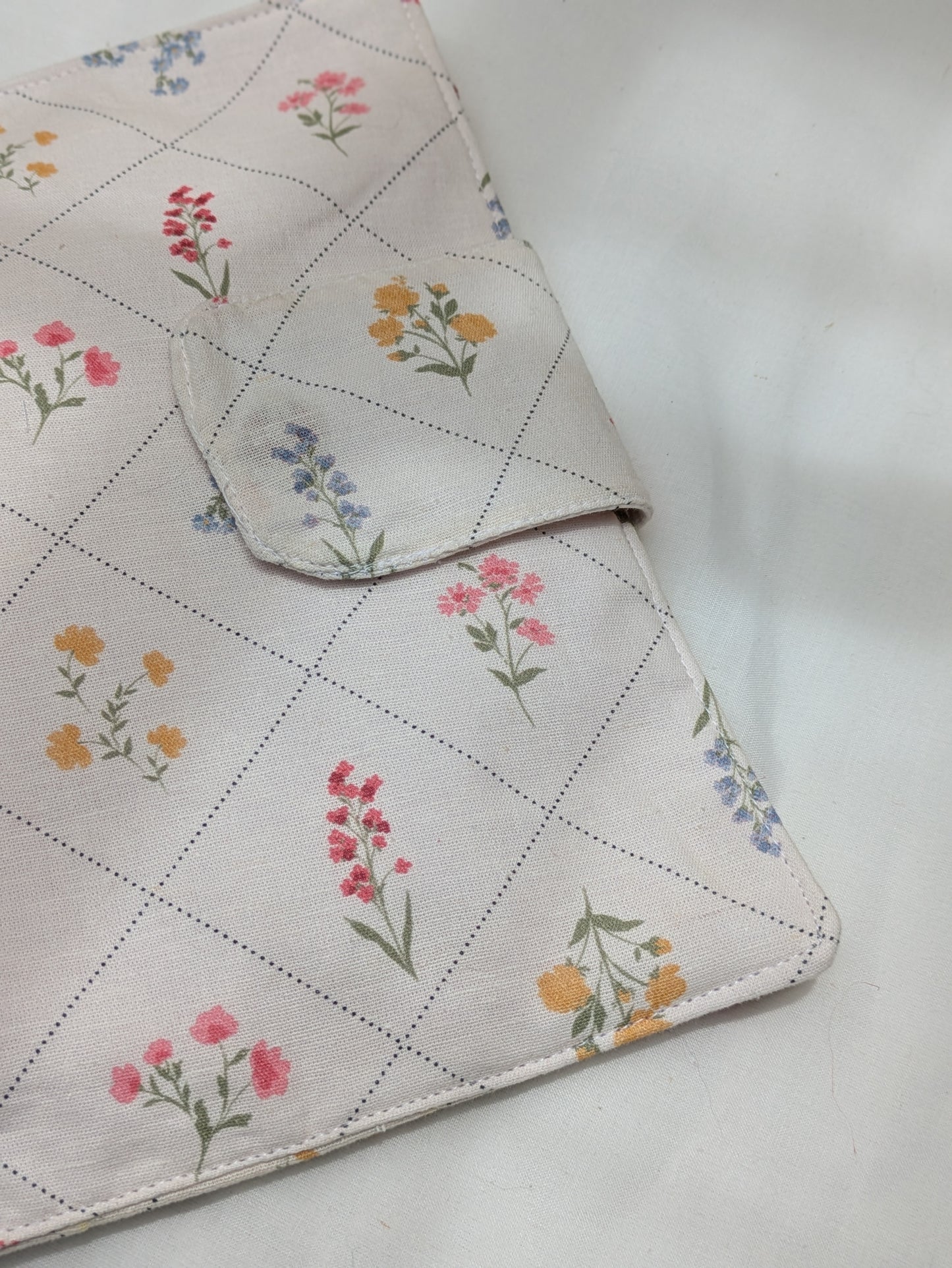 Floral-patterned fabric with a checkered border on a white background