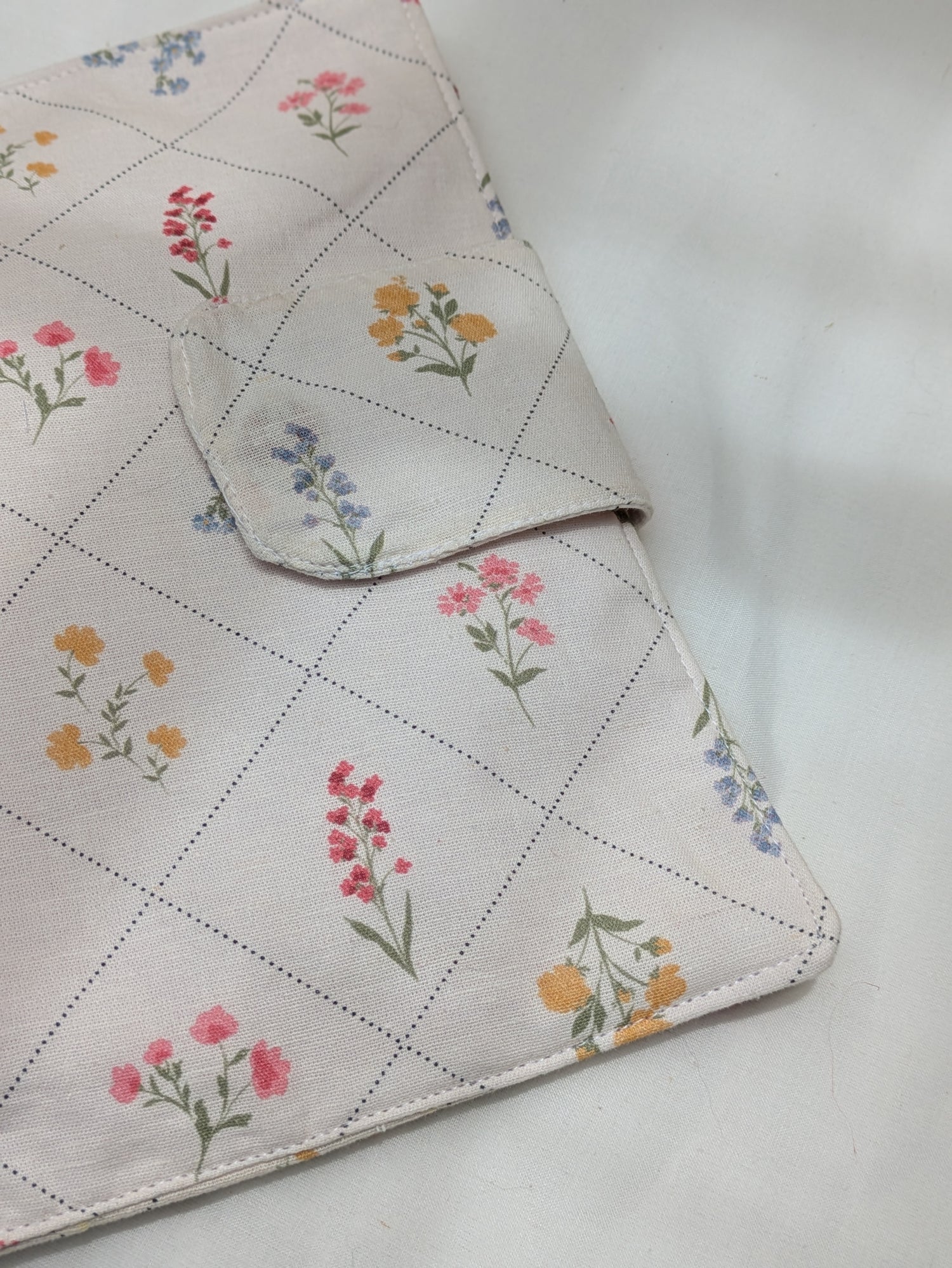 Floral-patterned fabric with a checkered border on a white background