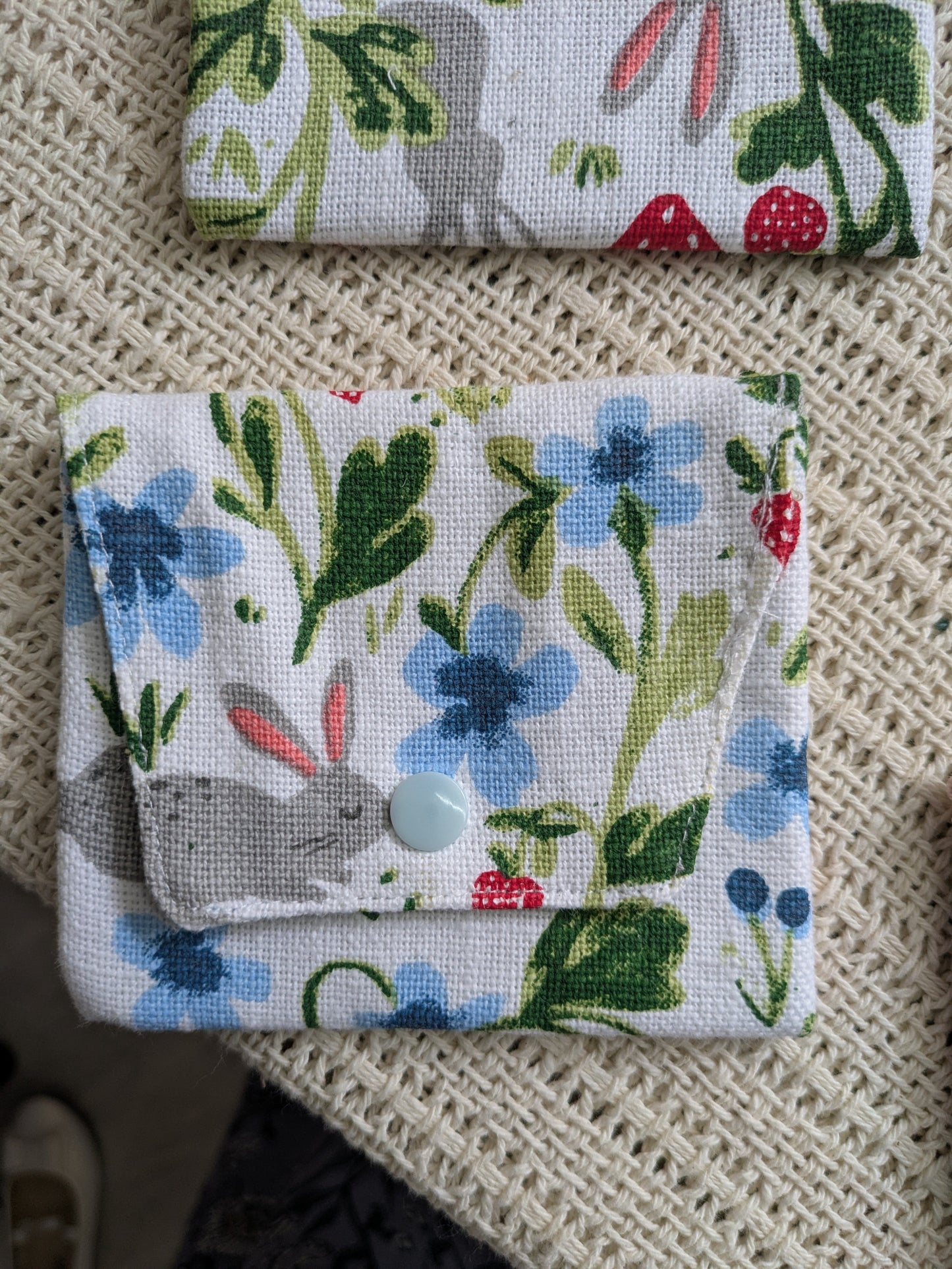Two fabric pouches with floral patterns on a textured surface