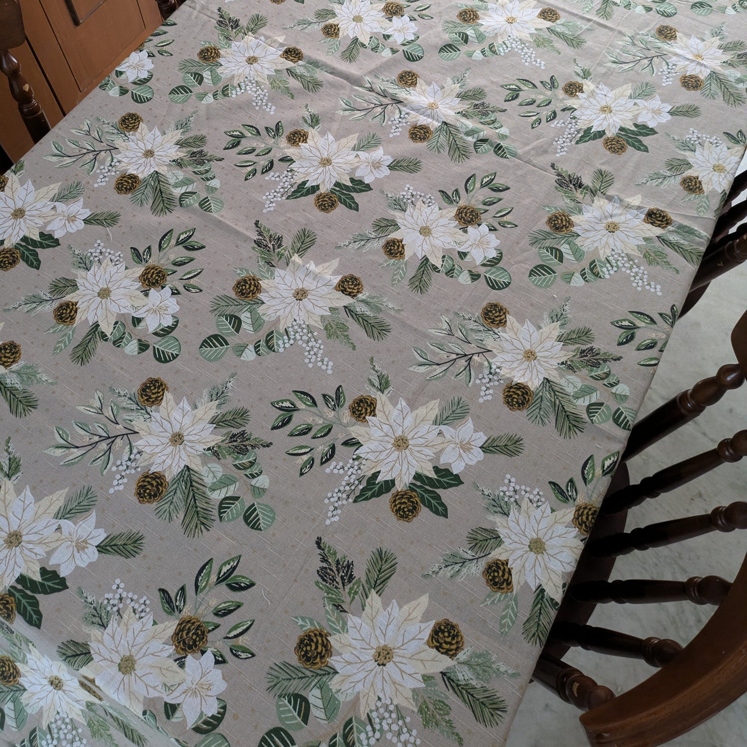 Floral patterned tablecloth on a dining table with wooden chairs.