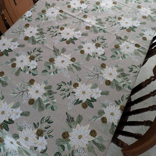 Floral patterned tablecloth on a dining table with wooden chairs.