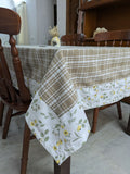 Dining table with a checkered and floral-patterned tablecloth in a home setting.