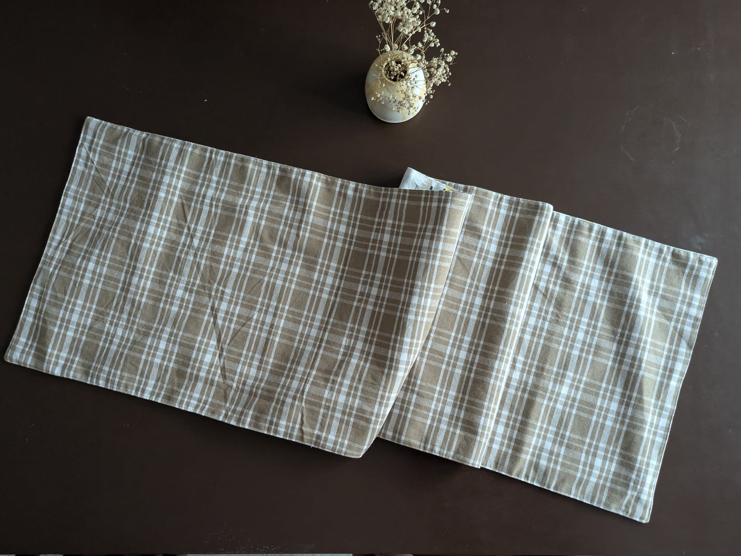 Floral patterned fabric with yellow flowers and green leaves on a white background.