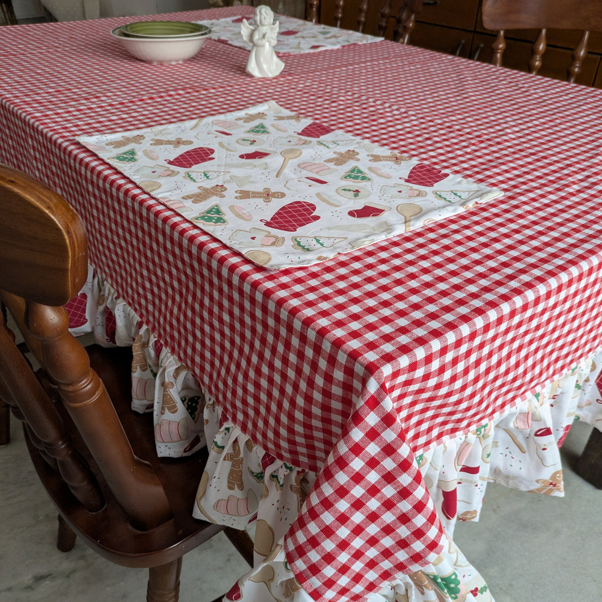 Tablecloth with red checkered pattern and gingerbread design on a wooden table.