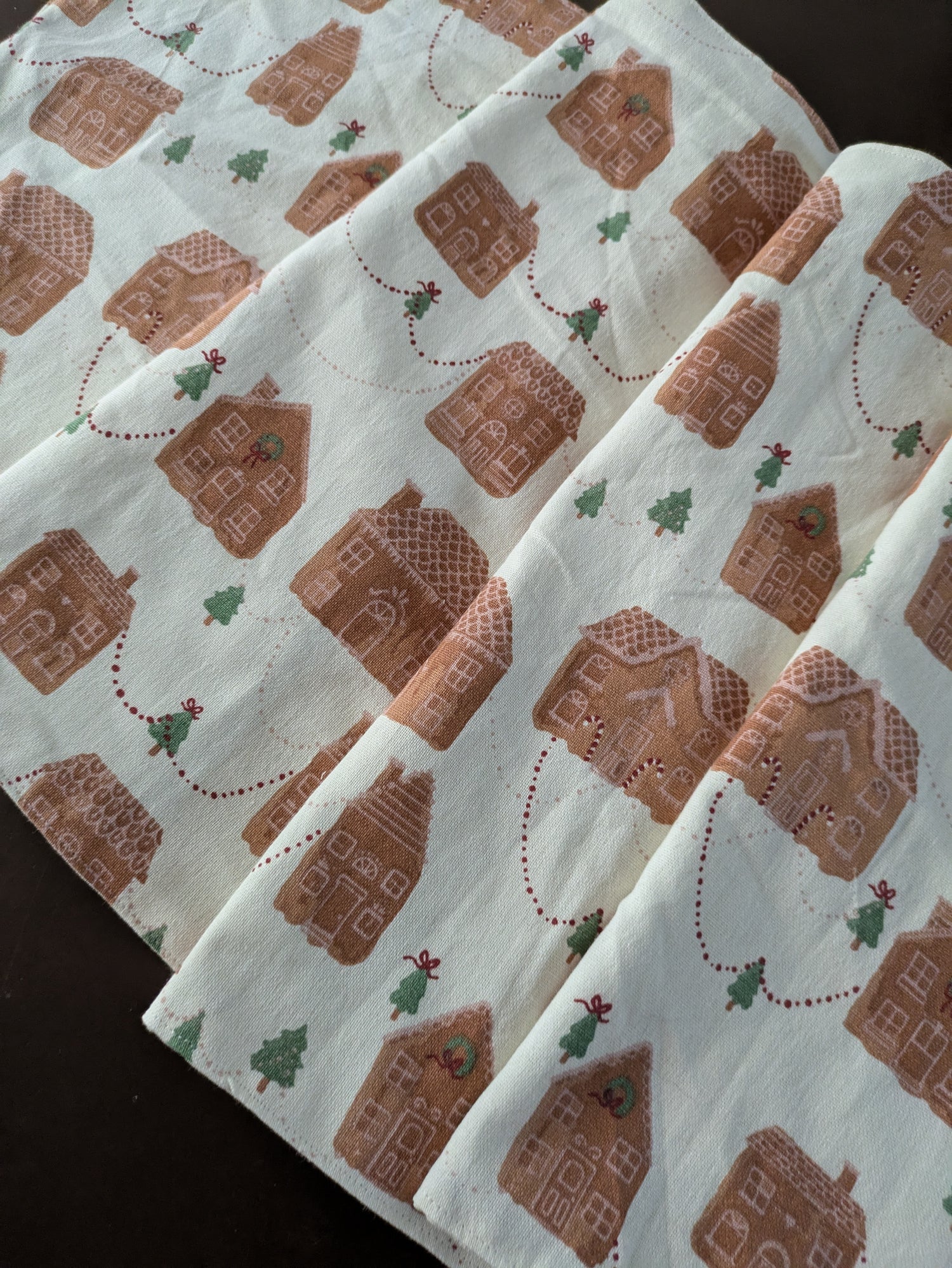 Fabric with gingerbread house pattern on a dark surface
