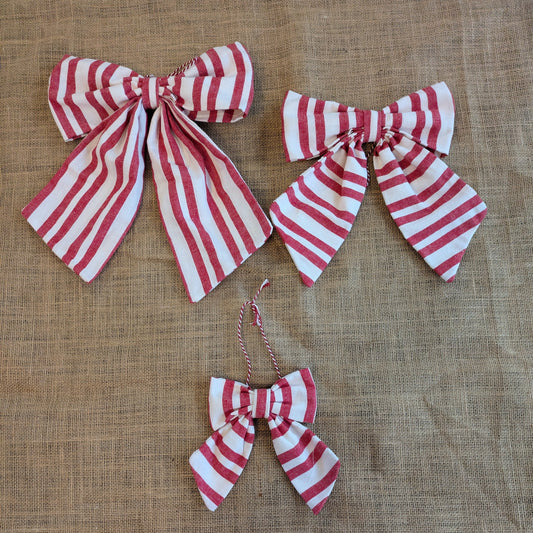 Red and white striped bows on a textured brown background