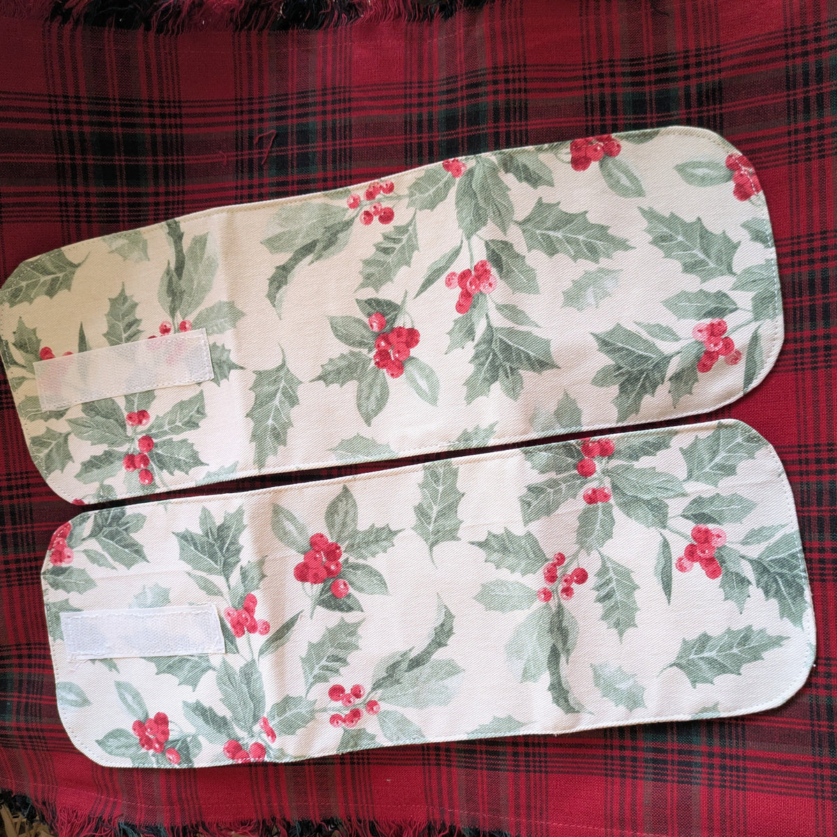 Two floral-patterned seat covers on a red plaid fabric background