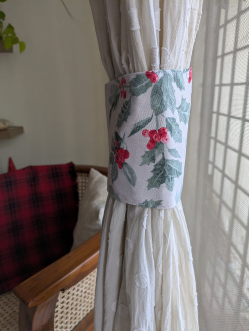 Decorative curtain tieback with floral pattern on a white curtain