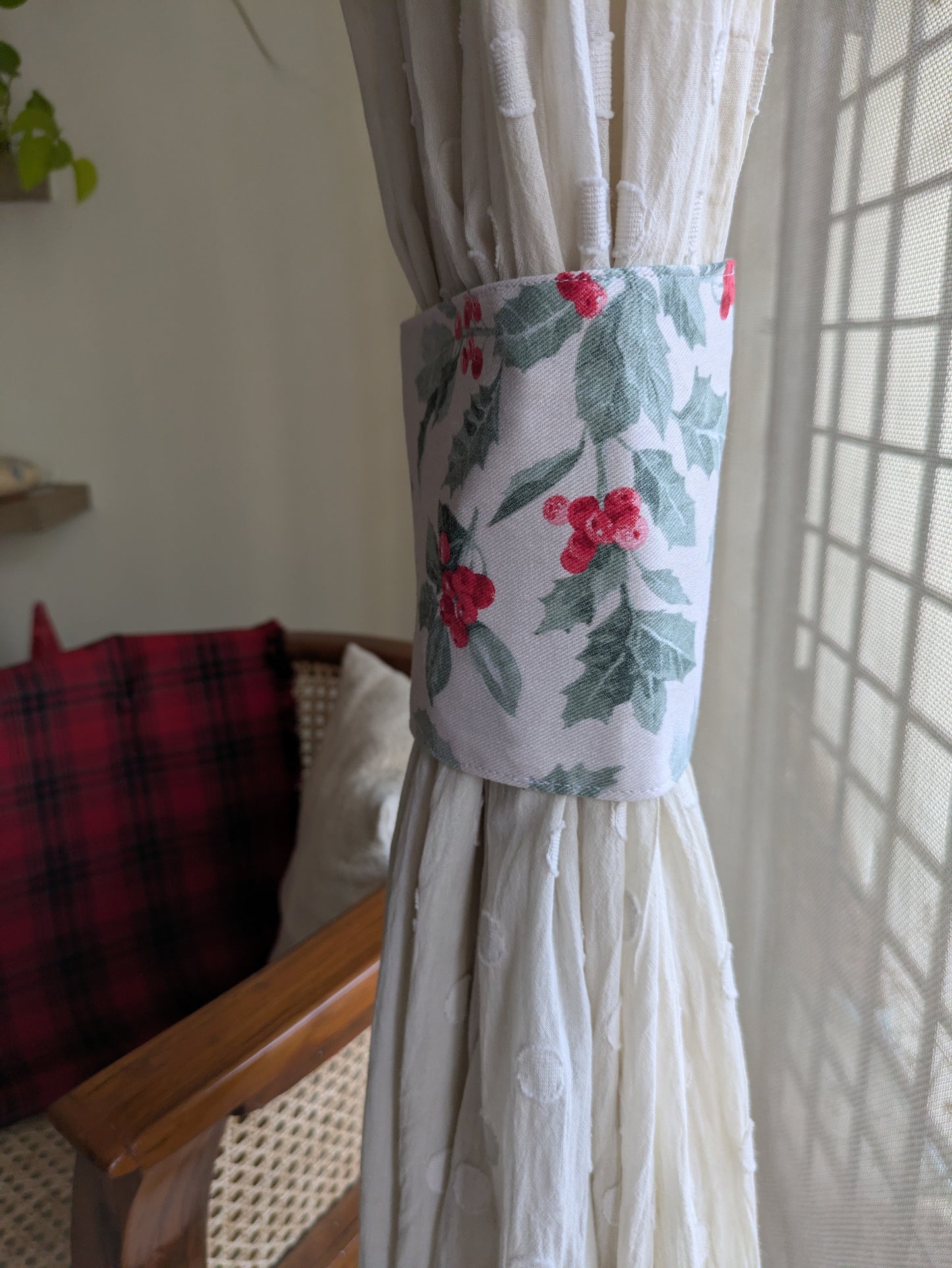 Decorative curtain tieback with floral pattern on a white curtain