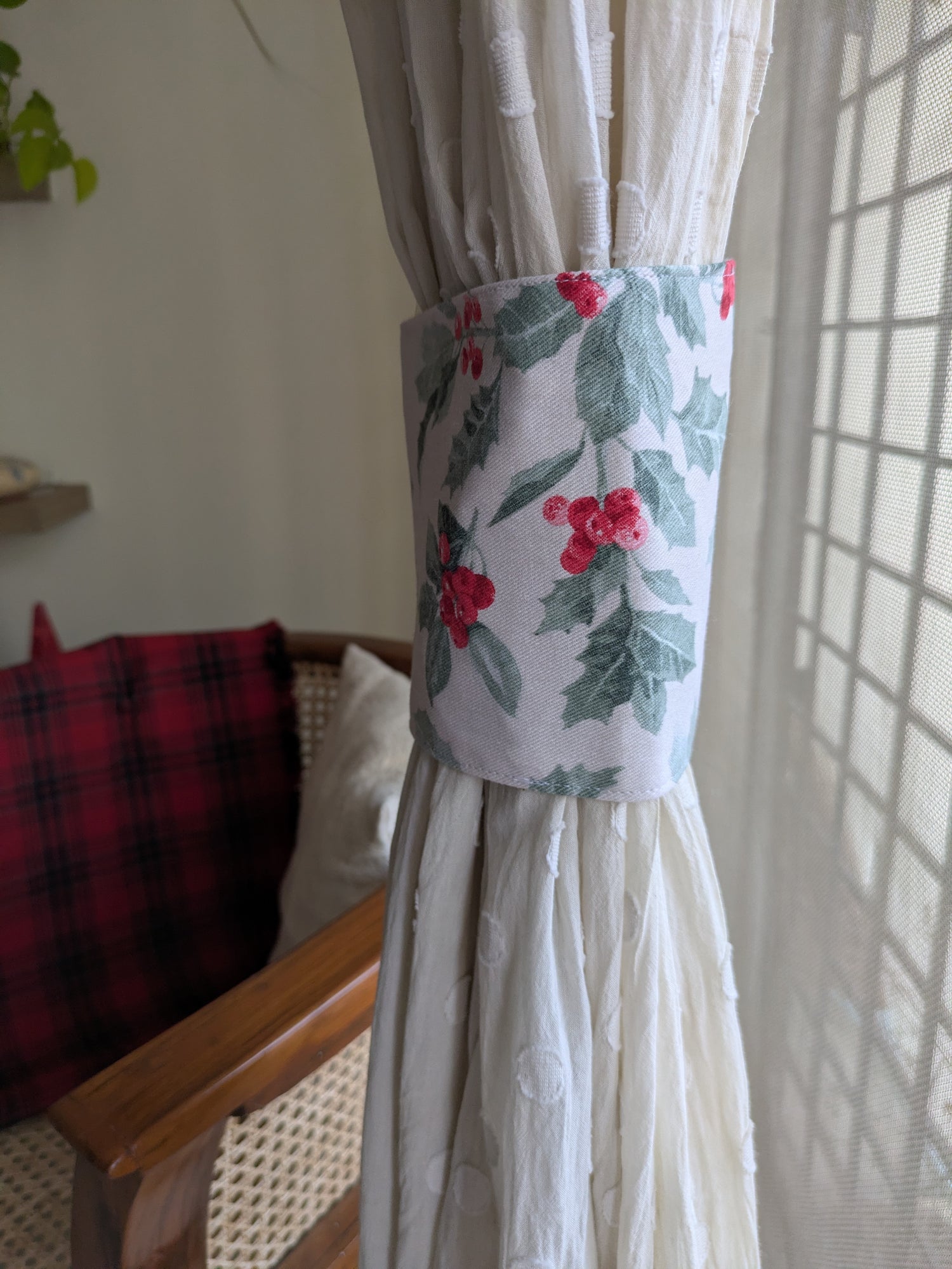 Decorative curtain tieback with floral pattern on a white curtain