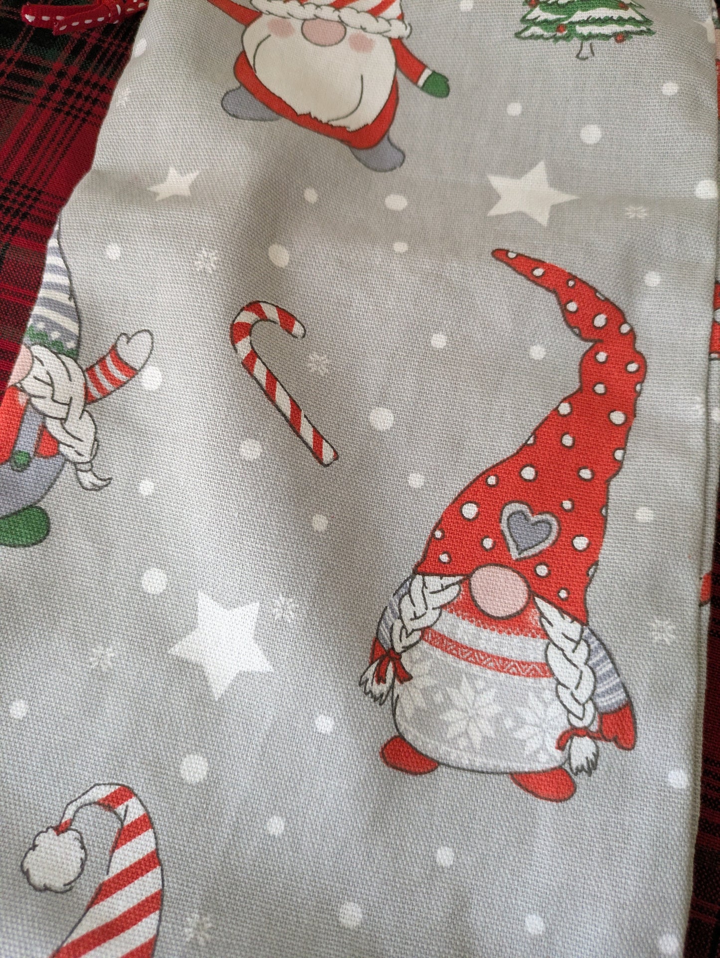 Fabric with Christmas-themed design featuring gnomes, candy canes, and stars on a gray background.