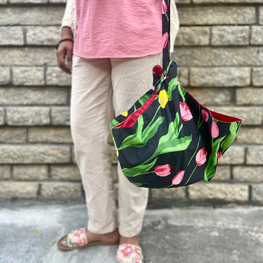 A woman carrying a casserole dish neatly wrapped in a casserole carrier.