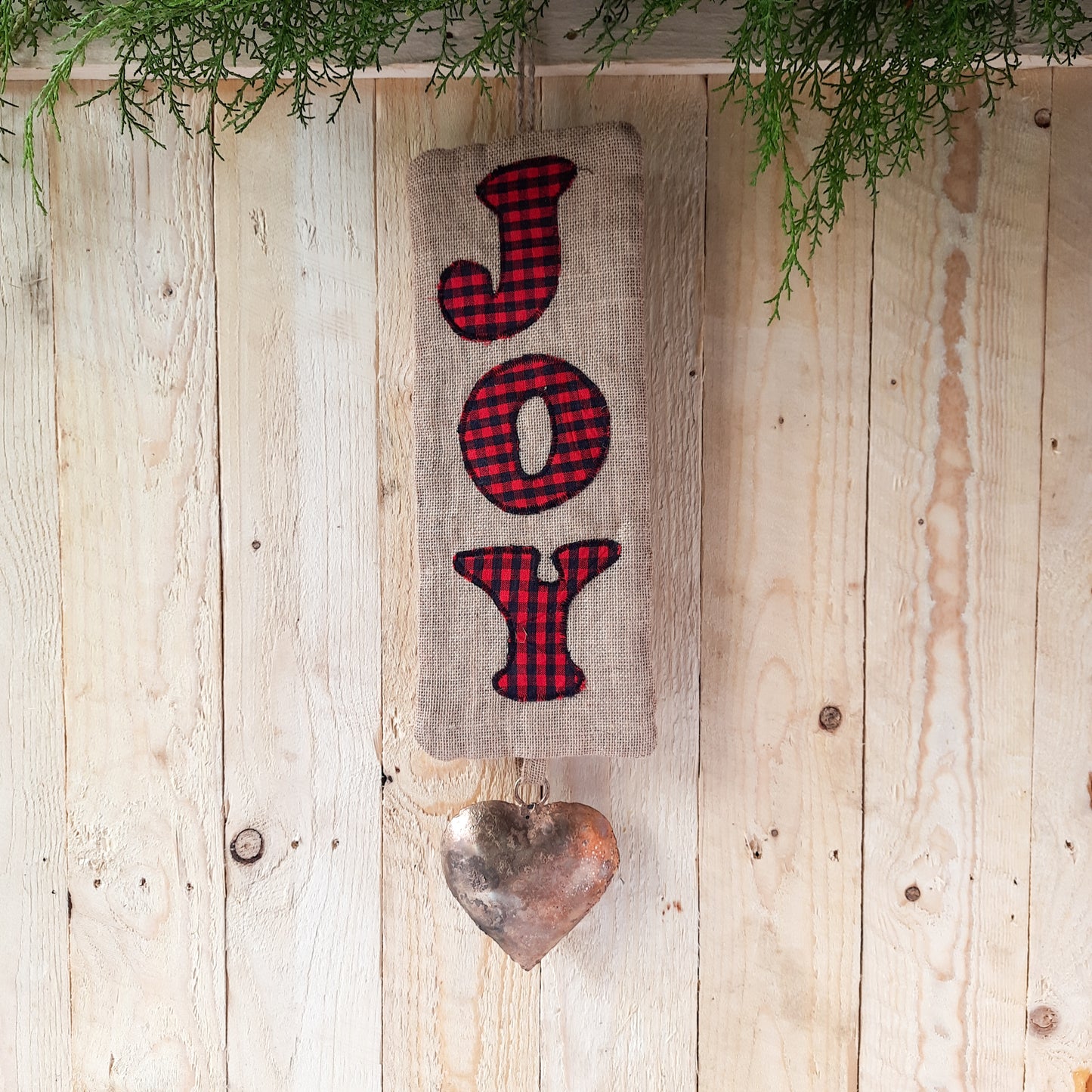 Handmade wall hanging made in natural burlap and finsihed with machine applique. the hanging metal art in heart shape adds to the rustic charm.